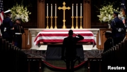 People pay their respects as the flag-draped casket of former President George H.W. Bush lies in repose at St. Martin's Episcopal Church, Dec. 5, 2018, in Houston.