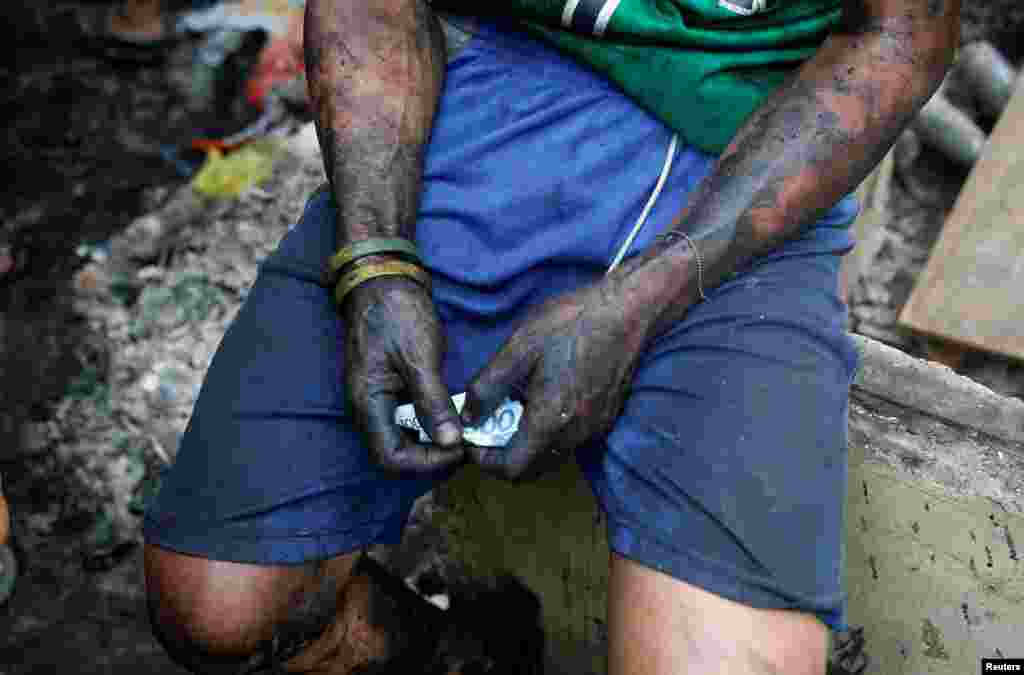 필리핀 마닐라 인근 만달루용의 주택가에서 한 남성이 불에 탄 집에서 나온 재활용품을 팔아 번 돈을 손에 거머쥐고 있다.