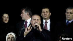 Turkey's Prime Minister Tayyip Erdogan (C) addresses his supporters upon his arrival to Ataturk Airport in Istanbul, Dec. 27, 2013.