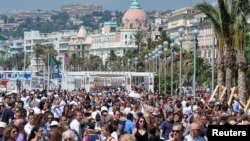Les gens se rassemblent avant la minute de silence sur la Promenade des Anglais après l'attentat de Nice, à Nice, France, le 18 juillet 2016.