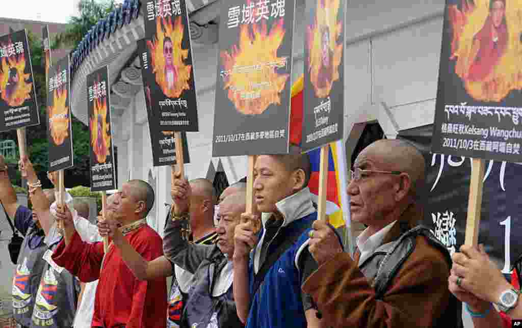 Tibetans display portraits of people who killed themselves in self-immolation, during a protest in front of the Liberty Square in Taipei on October 19, 2011. (AFP)
