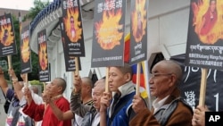 Tibetans display portraits of people who killed themselves in protest of Chinese policies in Tibet, Liberty Square, Taipei, October 19, 2011.