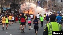 FILE - Runners continue to run towards the finish line of the Boston Marathon as an explosion erupts near the finish line of the race in this photo exclusively licensed to Reuters by photographer Dan Lampariello after he took the photo in Boston, Massachusetts, April 15, 2013.