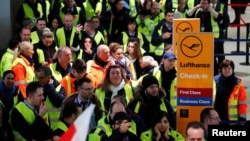 Security personnel at Cologne-Bonn Airport gather at a check-in counter of German airline Lufthansa during a strike called by union Verdi to put pressure on management in wage talks in Cologne, Germany, Jan. 10, 2019.