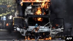18일 베네수엘라 수도 카라카스에서 개헌의회 구성에 반대하는 시위대가 길을 막고 트럭에 불을 지르고 있다.
