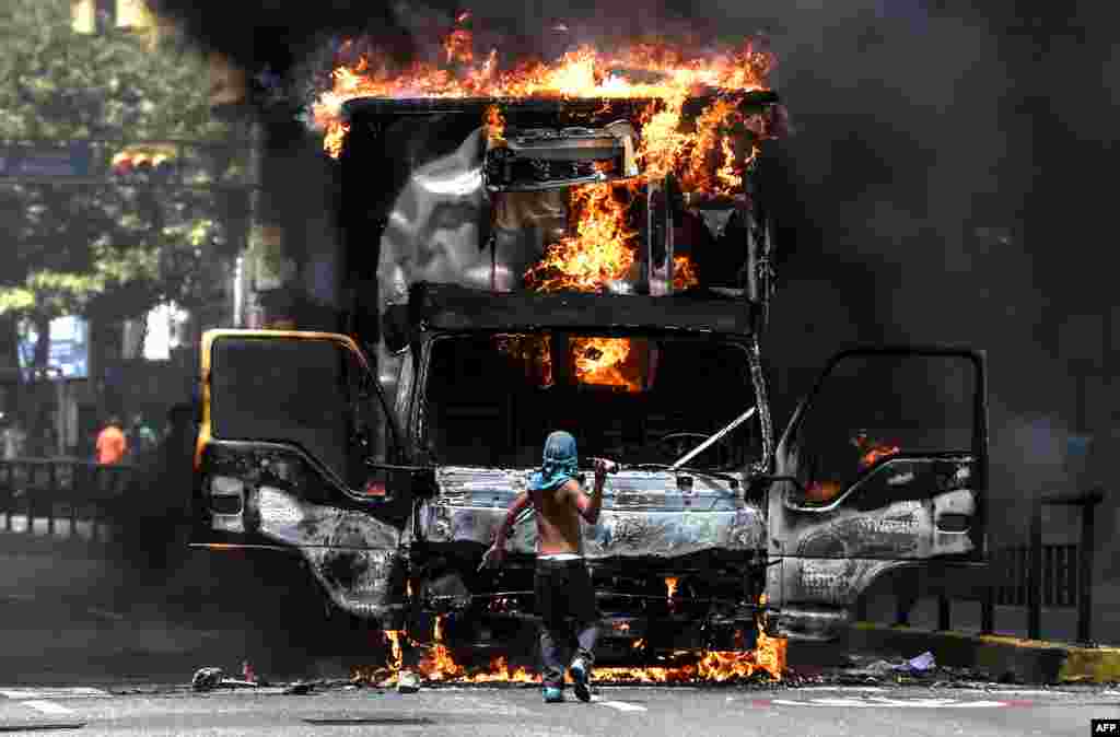 A truck set ablaze by opposition activists blocking an avenue during a protest burns in Caracas, Venezuela.