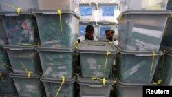 Afghan electoral workers sort ballot boxes at a counting center in Kabul, April 10, 2014. 