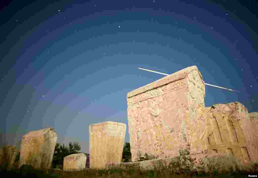 A meteor streaks past stars in the night sky above medieval tombstones during the Perseid meteor shower in Radimlja near Stolac, Bosnia and Herzegovina, Aug. 12, 2019.