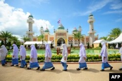 Girls walk past Pattani mosque whilst waiting for the arrival of Thai Crown Prince Maha Vajiralongkorn during a royal visit to the southern Thai province of Narathiwat Nov. 14, 2016.