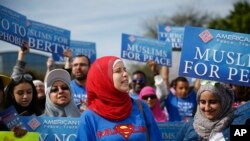 FILE - Protesters stand across the street from a Donald Trump rally holding signs before a campaign rally in Orlando, Florida.