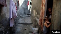 Palestinian children look out of their homes at Al-Shati refugee camp in Gaza City, Sept. 3, 2018.