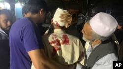 Un herido es ayudado por dos personas en el hospital luego de una enorme explosión en Kabul, el 2 de septiembre de 2019, en el complejo Green Village, sede de varias organizaciones internacionales y residencias de huéspedes. AP/Rahmat Gul.