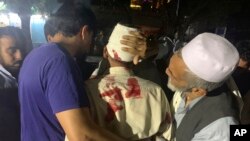 Para pria Afghanistan memapah seorang pria yang cedera di rumah sakit setelah ledakan besar di Kabul, Afghanistan, 2 September 2019.
