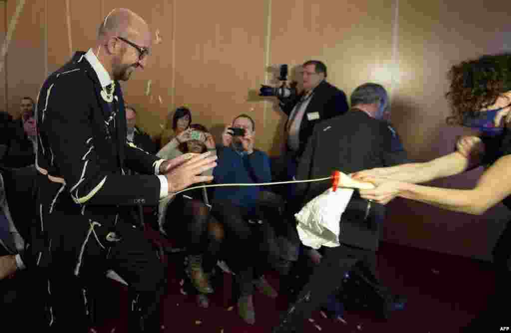 Belgian Prime Minister Charles Michel (L) reacts as activists throw fries and mayonnaise on him during an anti-government protest by feminist activist group LilithS (formerly the Belgian branch of Femen) at a press conference at the Cercle de Wallonie in Namur.