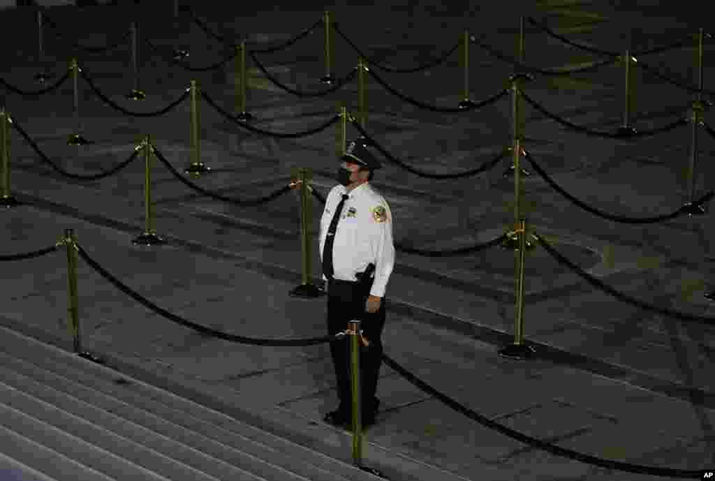 A security guard stops to pay respects after the line of mourners closed as Justice Ruth Bader Ginsburg lies in repose under the Portico at the top of the front steps of the U.S. Supreme Court building in Washington, Sept. 24, 2020.