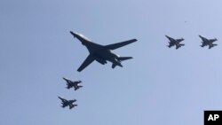 Pesawat pembom B-1 milik AS (tengah) terbang di atas pangkalan udara Osan bersama jet-jet Amerika di Pyeongtaek, Korea Selatan (13/9). (AP/Lee Jin-man)
