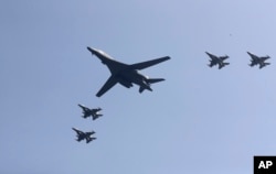 U.S. B-1 bomber, center, flies over Osan Air Base with U.S. jets in Pyeongtaek, South Korea, Tuesday, Sept. 13, 2016.