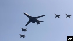 ABŞ-a məxsus B-1 bombardmançı təyyarəsi qırıcıların müşayiəti ilə Osan Hava Bazası üzərindən uçur. Pyeonqtaek, Cənubi Koreya. 13 sentyabr, 2016.