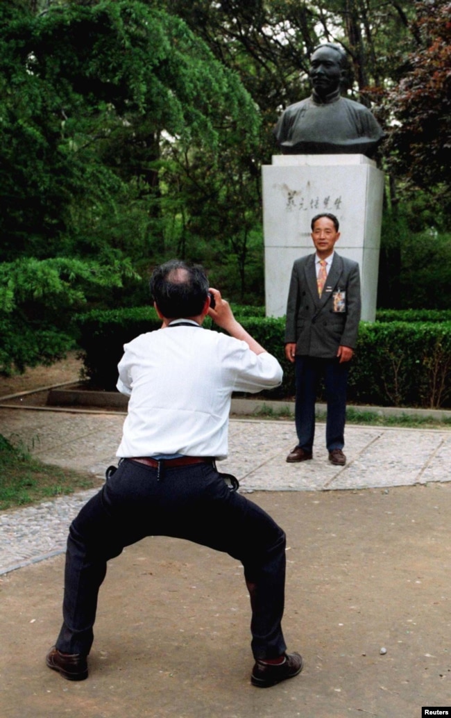 北京大學校友在中國最著名的教育家之一，北京大學前校長蔡元培的塑像前拍攝紀念照。