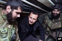 FILE - Syrian President Bashar Assad, center, speaks with Syrian troops during his visit to the front line in the eastern Damascus district of Jobar.