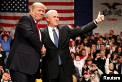 U.S. President-elect Donald Trump shakes hands with Vice President-elect Mike Pence (R) at the USA Thank You Tour event at the Iowa Events Center in Des Moines, Iowa, Dec. 8, 2016.