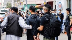 Leung Kam-wai, one of the arrested members of the Hong Kong Alliance in Support of Patriotic Democratic Movements of China, is escorted by police as they leave after a search of the June 4th Museum, in Hong Kong, Sept. 9, 2021.