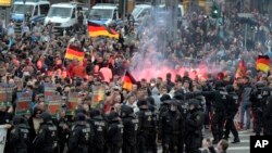 Para pengunjuk rasa dari kelompok ultra kanan menyalakan kembang api saat berdemonstrasi di Chemnitz, Jerman, Senin, 27 Agustus 2018.