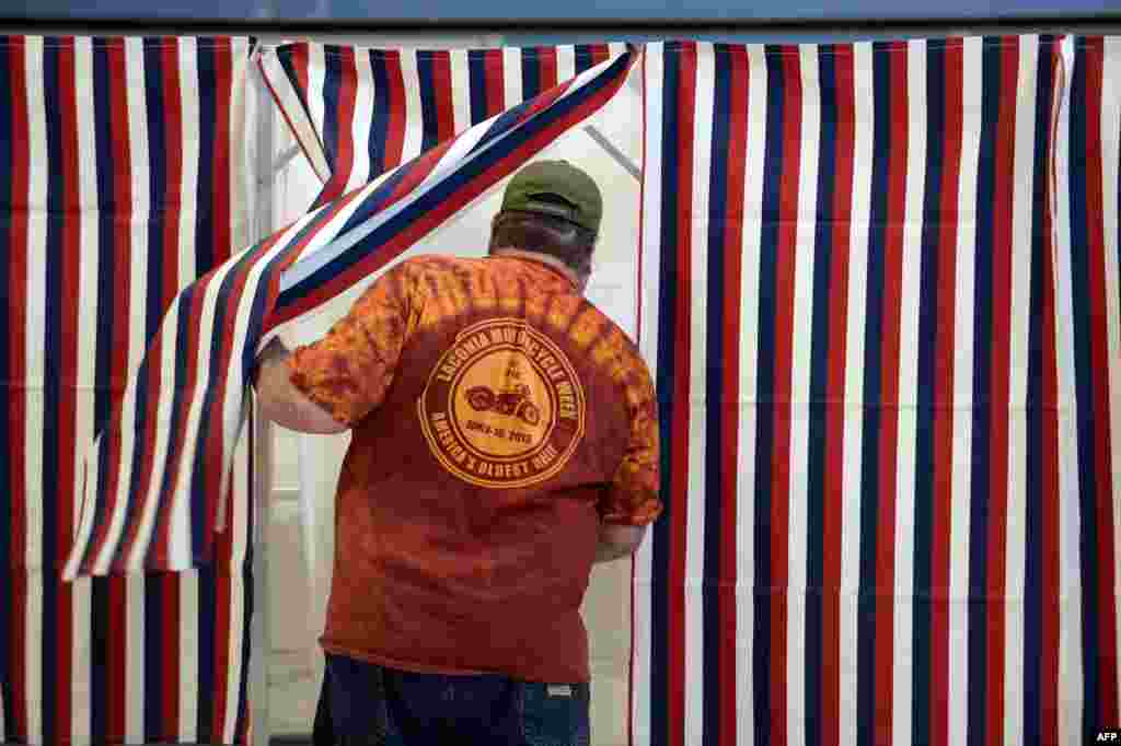 A voter enters the voting booth at Bishop Leo E. O'Neil Youth Center in Manchester, New Hampshire, Nov. 4, 2014. New Hampshire features a tight race between incumbent U.S. Senator Jeanne Shaheen (D-NH) and former Massachusetts U.S. Senator Scott Brown.