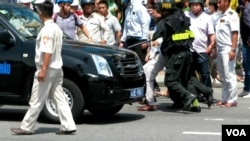 Một kẻ quấy rối biểu tình ở Đà Nẵng bị bắt đưa lên xe.