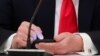 Predsednik Donald Tramp dodiruje ekran svog mobilnog telefona (Foto: REUTERS/Leah Millis)