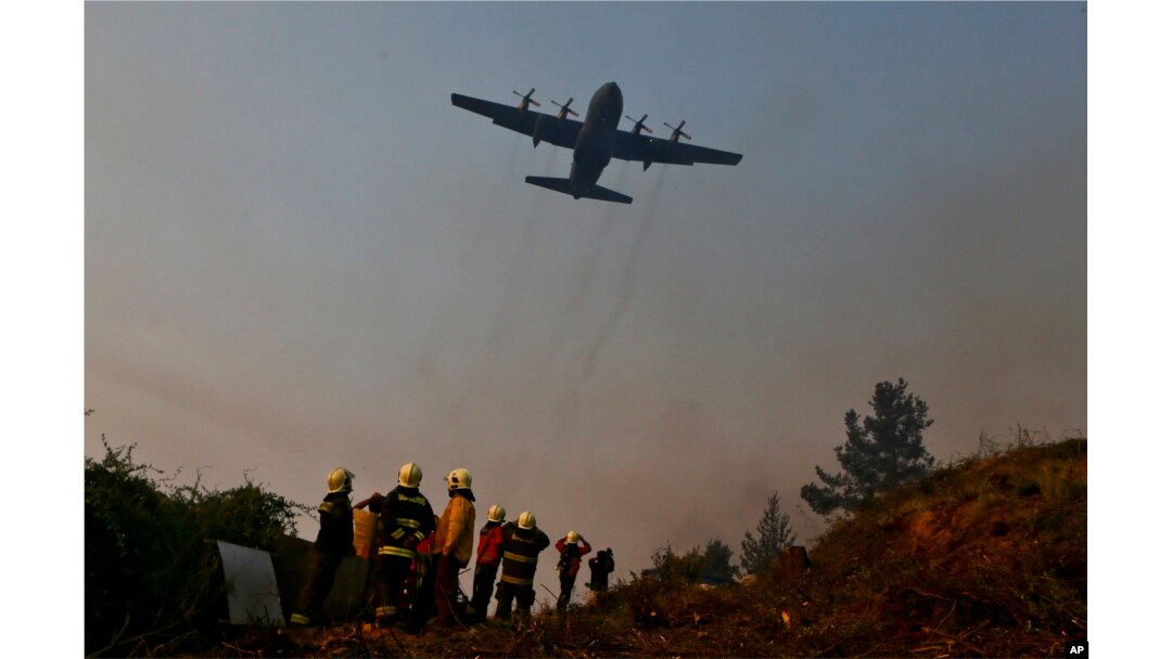 A Brazilian C-130 Hercules aircraft helps to fight the wildfire approaching Chile's community of Dichato, Jan. 30, 2017.