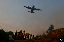 A Brazilian C-130 Hercules aircraft helps to fight the wildfire approaching Chile's community of Dichato, Jan. 30, 2017.