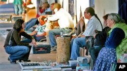 Sellers and buyers trade in Old Town Albuquerque, New Mexico on Feb. 8, 2006. Native American who produce artwork say fake art causes them to go out of business. Some fake Native American artwork is made abroad. 