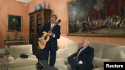 U.S. Secretary of State John Kerry (L) poses with a guitar, given as a present by Spanish Foreign Minister Jose Manuel Garcia-Margallo, during a meeting at the Foreign Ministry in Madrid, October 18, 2015. 