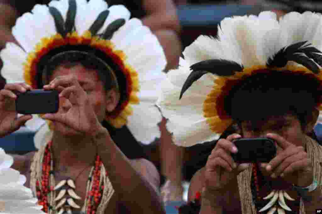 Rikibaktsa Indians take pictures with cell phones during the Indigenous Games on the island of Porto Real in the city of Porto Nacional, Brazil, Monday Nov. 7, 2011. Indigenous people from 38 ethnic groups are participating in the XI Indigenous Games, in 