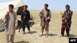 Members of an Afghan militia look on during fighting between Taliban militants and Afghan security forces near the Qala-e-Zal district in Kunduz province, May 7, 2017.