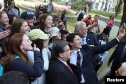 FILE - Prime Minister of Canada Justin Trudeau (C), Montreal Mayor Denis Coderre (L) and Quebec Premier Philippe Couillard (R) take a selfie with a group of young tourists during Montreal's 375th Birthday Celebrations in Montreal, Canada May 17, 2017. (REUTERS/Dario Ayala)