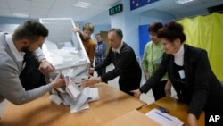 Members of a local election commission open a ballot box to count votes after a day of election at a polling station in Kiev, Ukraine, Oct. 25, 2015.