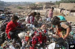 Pakistan children sort through garbage for recycleable items to sell, at a dump in Karachi, April 4, 2019.