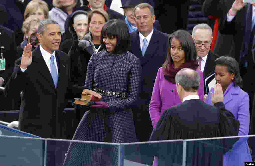 U.S. Supreme Court Chief Justice John Roberts (2nd from R) administers the oath of office to U.S. President Barack Obama (L) as first lady Michelle Obama (C) and daughters Malia and Sasha (R) look on during ceremonies on the West front of the U.S Capitol 