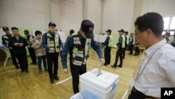 A South Korean police officer casts his early vote for the upcoming May 9 presidential election at a local polling station in Seoul, South Korea, May 4, 2017. 