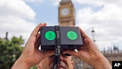 Ảnh tư liệu - Một người đàn ông nhìn qua thiết bị thực tế ảo cho thấy hình ảnh 360 độ của thành phố Aleppo, Syria, trong cuộc biểu tình của tổ chức Ân xá Quốc tế ở Quảng trường Parliament, London, ngày 11 tháng 7 năm 2015.