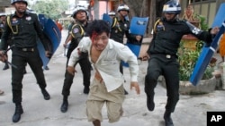 11月12日,在金邊一所佛寺大院，一名受傷的柬埔寨工人逃離防暴警察追打。 