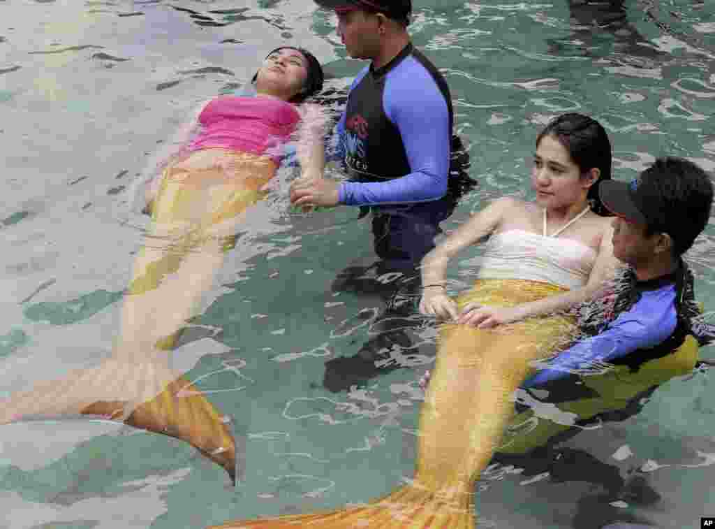 Para instruktur renang memberikan latihan renang untuk anak-anak dan orang dewasa degan mengenakan kostum putri duyung yang merupakan daya tarik terbaru di oceanarium terbesar di negara itu, di Manila, Filipina. &nbsp;