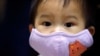 Seorang anak laki-laki mengenakan masker sebelum menerima vaksinasi Influenza di sebuah rumah sakit di Taipei, 9 November 2009.