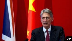 FILE - British Foreign Secretary Philip Hammond delivers his speech at Peking University in Beijing, Aug. 12, 2015. 