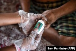 Penggunaan oksimeter untuk memeriksa pasien kusta sebagai bagian dari pemeriksaan kesehatan umum. (Foto: AFP/Sam Panthaky)