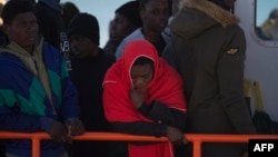 Migrants wait aboard a Spanish coast guard boat upon their arrival at Malaga's harbor on Dec. 10, 2018, after an inflatable boat carrying 118 migrants was rescued by the Spanish coast guard off the Spanish coast. 