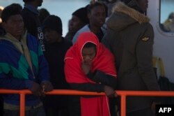 Migrants wait aboard a Spanish coast guard boat upon their arrival at Malaga's harbor on Dec. 10, 2018, after an inflatable boat carrying 118 migrants was rescued by the Spanish coast guard off the Spanish coast.