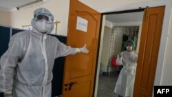 ရန်ကုန်မြို့ရှိ Quarantine စင်တာတခုမှာ COVID-19 ရောဂါရှိမရှိ စစ်ဆေးပေးဖို့ ဝတ်စုံပြည့်ဝတ်ထားတဲ့ စေတနာ့ဝန်ထမ်းများ (မေ ၁၆၊ ၂၀၂၀)